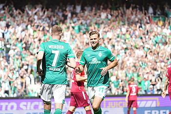 Die Werder-Profis Niclas Füllkrug und Marvin Ducksch klatschen nach einem Tor ab.