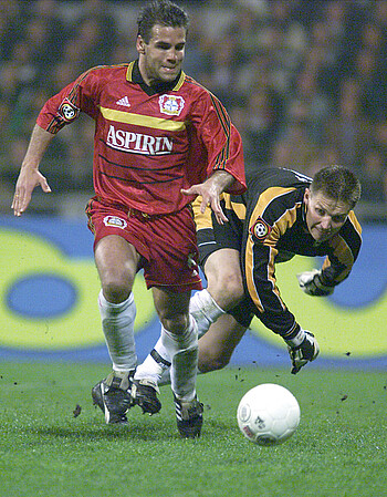 Frank Rost versucht einem Leverkusener Spieler den Ball wegzunehmen.