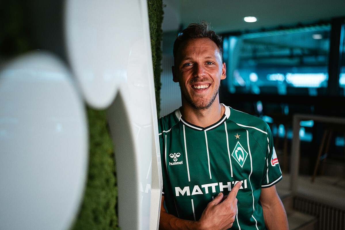 Senne Lynen pointing to the Werder logo. 