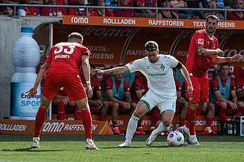 Mitchell Weiser dribbling alongside a Heidenheim player.