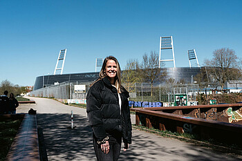 Lena Petermann lächelt, im Hintergrund steht das Weserstadion.