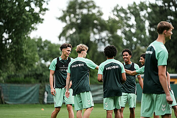Die U19-Spieler lachen im Training in der Gruppe. 