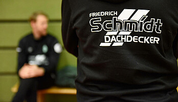 Logo von Dachdecker Schmidt auf einem Werder-Pullover.