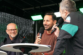 Claudio Pizarro auf der Bühne mit Mikrofon in der Hand.