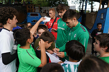 Die beiden U23-Spieler verteilen fleißig Autogramme. (Foto: Werder.de)