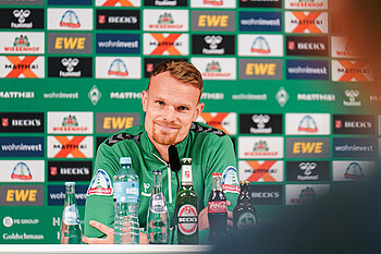 Christian Groß speaking to journalists in the press room.