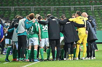 The Werder team huddle together before the start of extra time.
