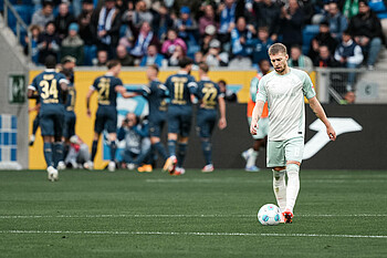 Mitchell Weiser guckt geknickt, im Hintergrund jubelt Hoffenheim.