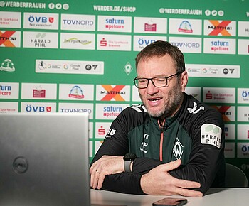 Thomas Horsch sitzt an einem Tisch und schaut auf einen Laptop.