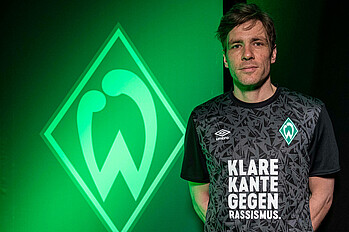 Clemens Fritz mit dem 'Klare Kante gegen Rassismus'-Shirt vor dem Werder Logo.