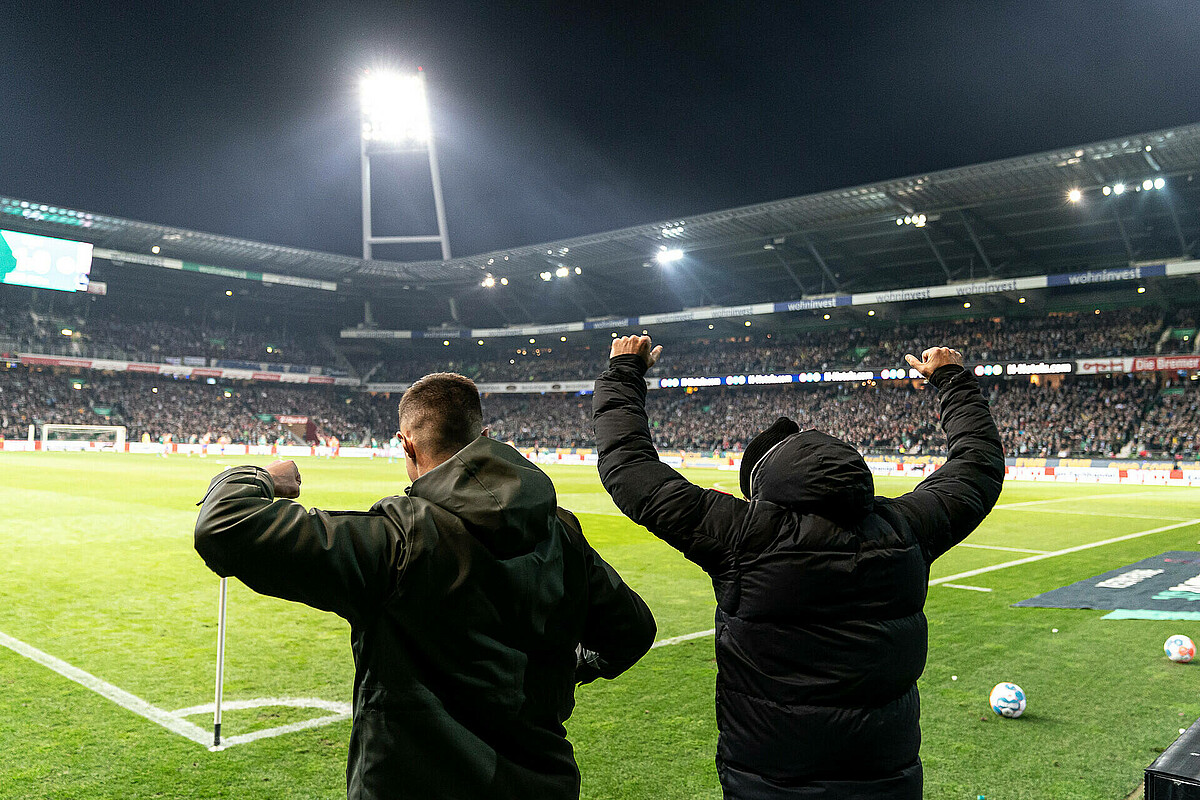 Marco Friedl und Ömer Toprak feiern am Spielfeldrand.