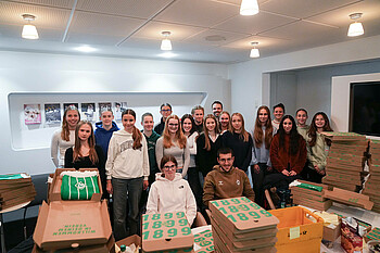 U17-Juniorinnen auf einem Gruppenfoto beim Packen für die Mitgliederkampagne