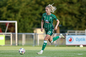 Sharon Beck läuft im grünen Trikot, grüner Hose und grünen Stutzen mit dem Ball am Fuß.