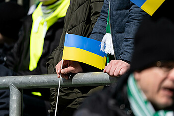 Ein Werder-Fan hält eine ukrainische Flagge in der Hand.
