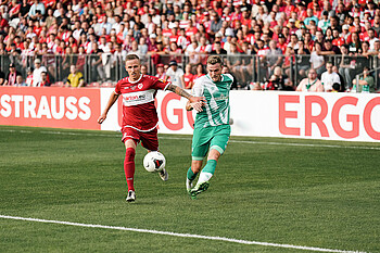 Marvin Ducksch mit einer Flanke gegen einen Gegenspieler. 