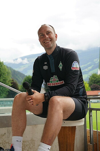 Ole Werner sits on a bar stool on the stage at Zillertal.