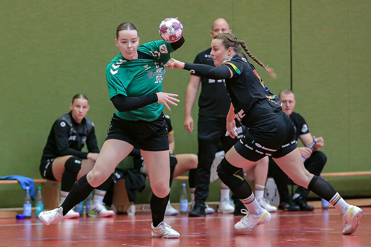 Eine Handballerin des SV Werder wird beim werfen am Trikot gezogen.