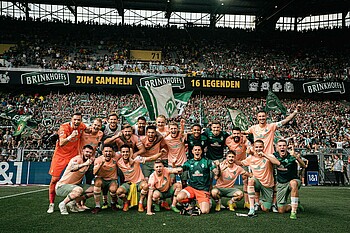 The team celebrating their win in front of the away fans.