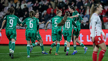 Michelle Ulbrich und Lara Schmidt jubeln zusammen. Mehrere Spielerinnen laufen auf die beiden zu.