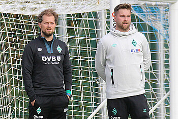 Atletiktrainer Julian Möller und Trainer Bastian Pollul stehen vor einem Tor.