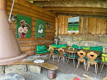 Eine Blockhütte mit sämtlichen Werder-Fanutensilien wie Bildern an der Wand sowie einer Tischgarnitur mit Werder-Kissen.