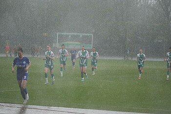 Die Spielerinnen laufen durch den Regen.