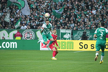 Marco Friedl köpft einen Ball vor dem Stürmer weg.