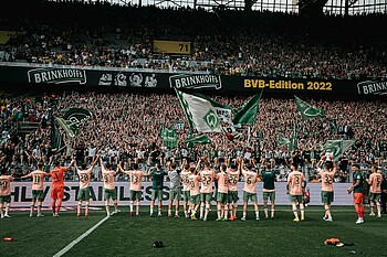 Die Werder-Spieler feiern nach dem Sieg gegen Dortmund vor der Fankurve.