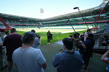 Fritzy Kromp hält das dritte Trikot bei hohem Medienaufkommen im Weserstadion hoch
