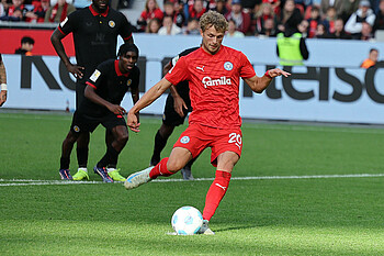 Fiete Arp einen Elfmeter aus, trägt dabei das rote Trikot der Kieler. 