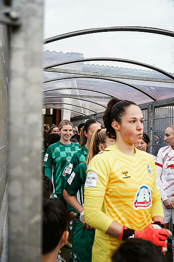 Kaylie Ronan steht im Spielertunnel und lächelt.