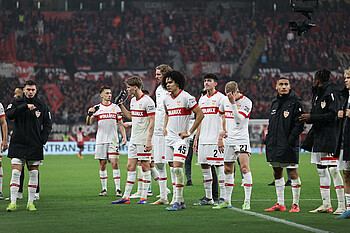 Die Stuttgarter Mannschaft steht mit hängenden Köpfen auf dem Rasen. 