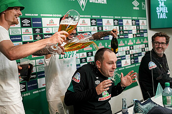 Die Werder-Spieler übergießen Trainer Ole Werner bei der Pressekonferenz mit Bier.