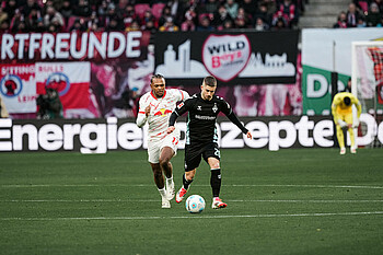 Romano Schmid mit Ball vor Openda. 