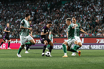Musiala mit Ball am Fuß umzingelt von Werder-Spielern. 