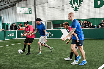 Männer spielen in einer Soccerhalle gegeneinander Fußball