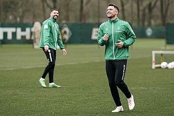 Milos Veljkovic und Anthony Jung lachend in Trainingsklamotten.