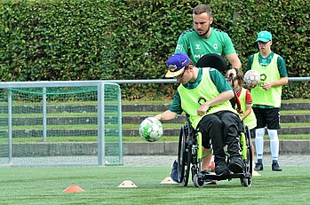 Ein Werder-Youngstar dribbelt im Rollstuhl um Hütchen.
