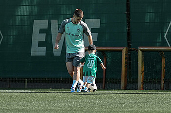 Romano Schmid playing with his son at training.