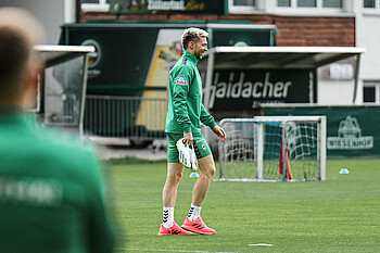 Mitchell Weiser geht lachend auf den Trainingsplatz.