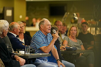 Ein Mitglied aus dem Publikum mit Mikrofon in der Hand.