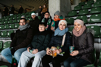 Menschen auf ihren Plätzen auf der Tribüne. 