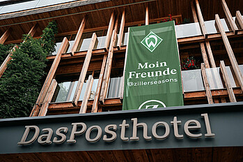 The exterior of the Posthotel with a Werder banner.