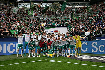 Die Werder-Mannschaft hat sich vor dem Fanblock für ein Foto hingestellt.