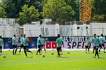 Die Werder-Spieler wärmen sich auf, im Hintergrund ist die Baustelle des Stadionumbaus zu sehen.