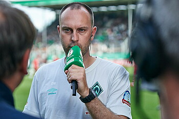 Ole Werner speaks into a microphone.