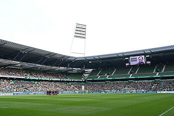 Beide Teams von Werder Bremen und Bayer Leverkusen stehen am Mittelkreis bei der Schweigeminute zu Ehren Dieter Burdenskis