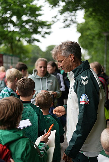 Horst Steffen schreibt nach dem Training Autogramme für Kinder