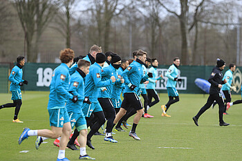 [Translate to Englisch:] Der Werder-Profis laufen sich im Training warm.
