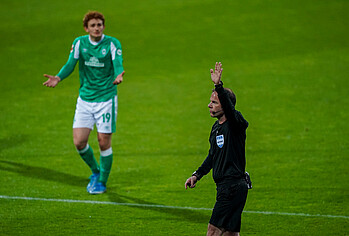 Referee Marco Fritz raises his arm.